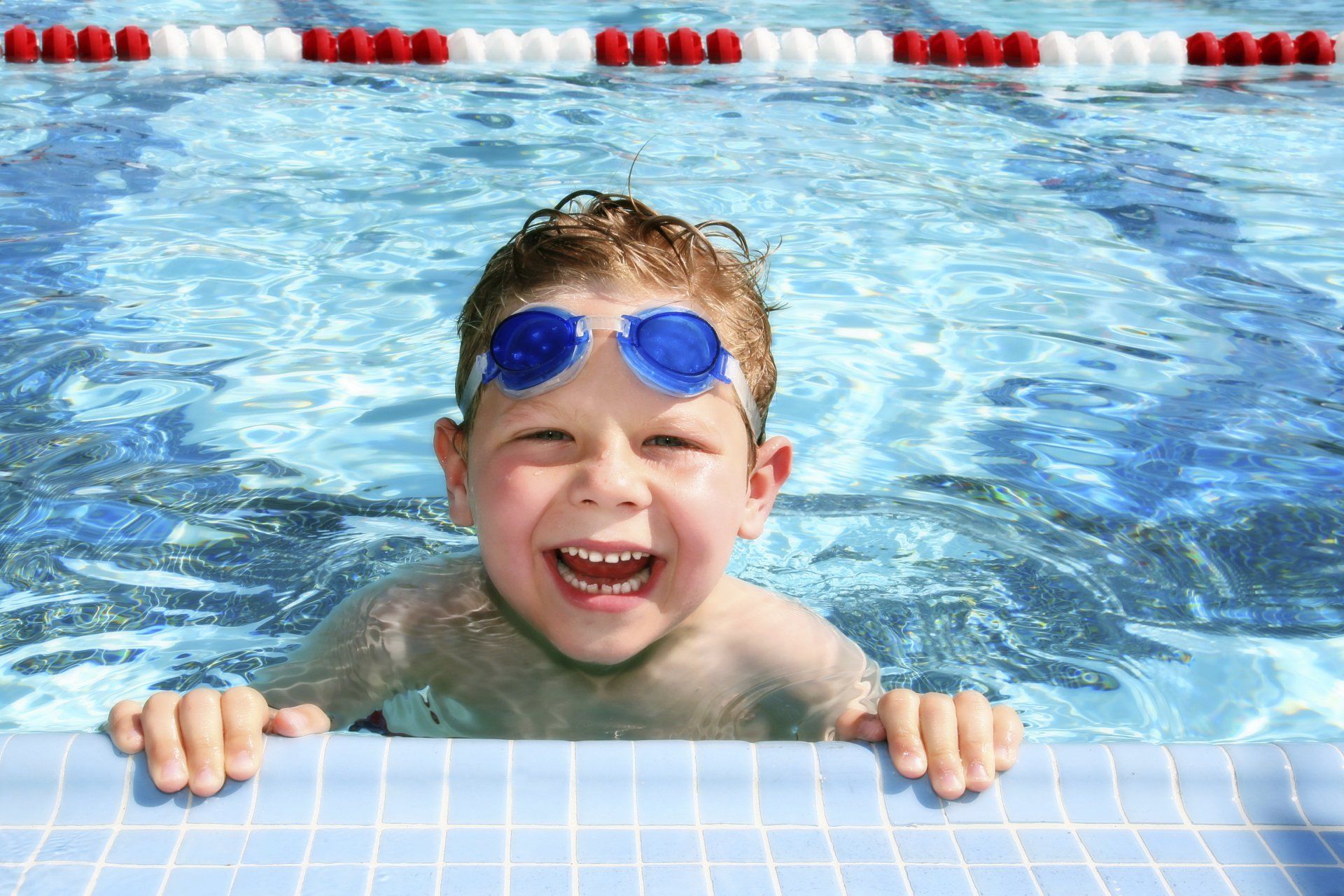 kids swim lessons BC - Happy child in swimming pool building water confidence